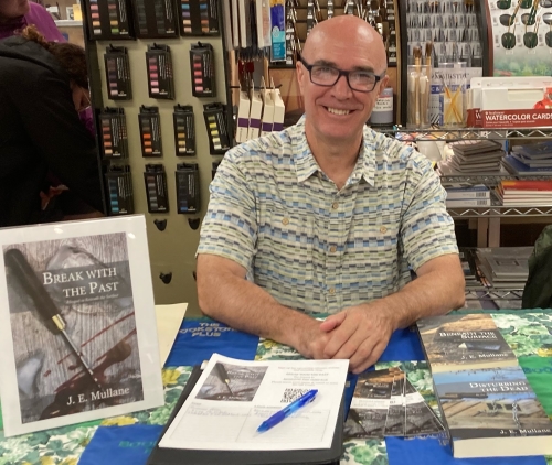 Author at table with his books, ready for signing at the Bookstore Plus in Lake Placid, NY